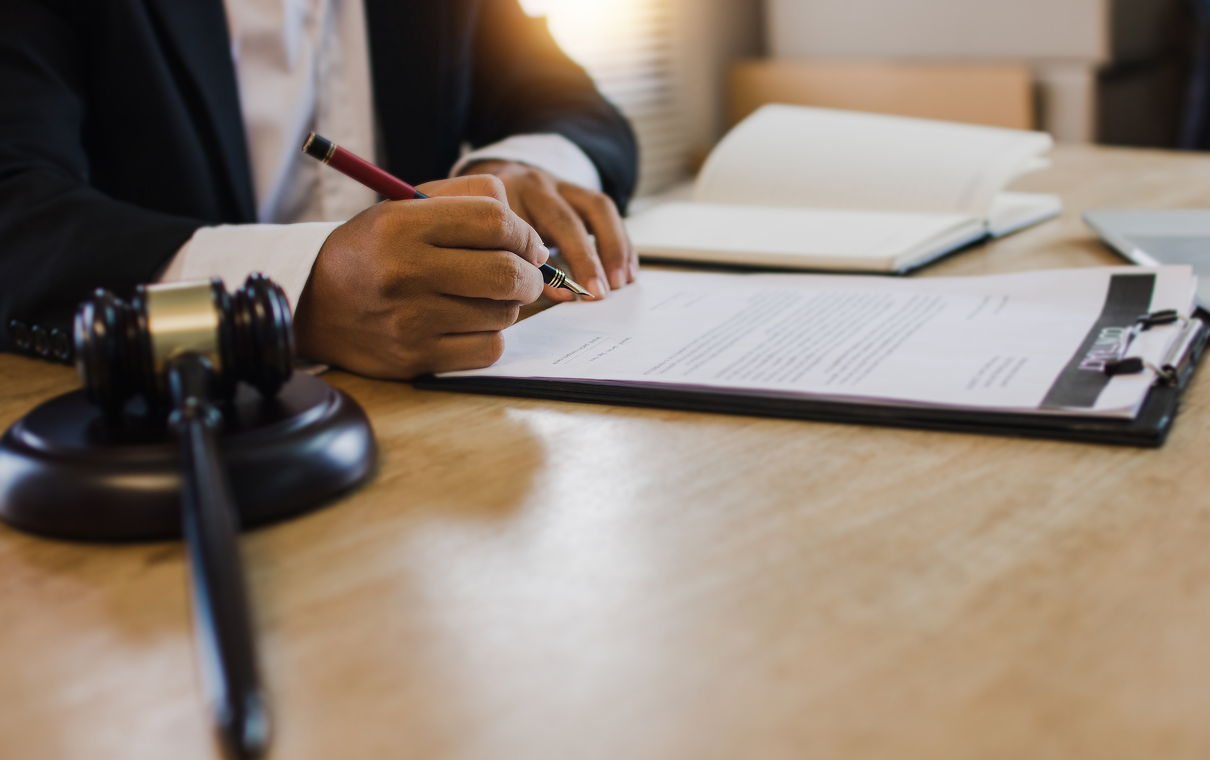 Lawyer signing legal documents at desk